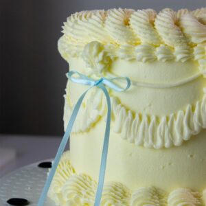 Afbeelding van blauwe lintstrik taarttoppers van PME op een taart